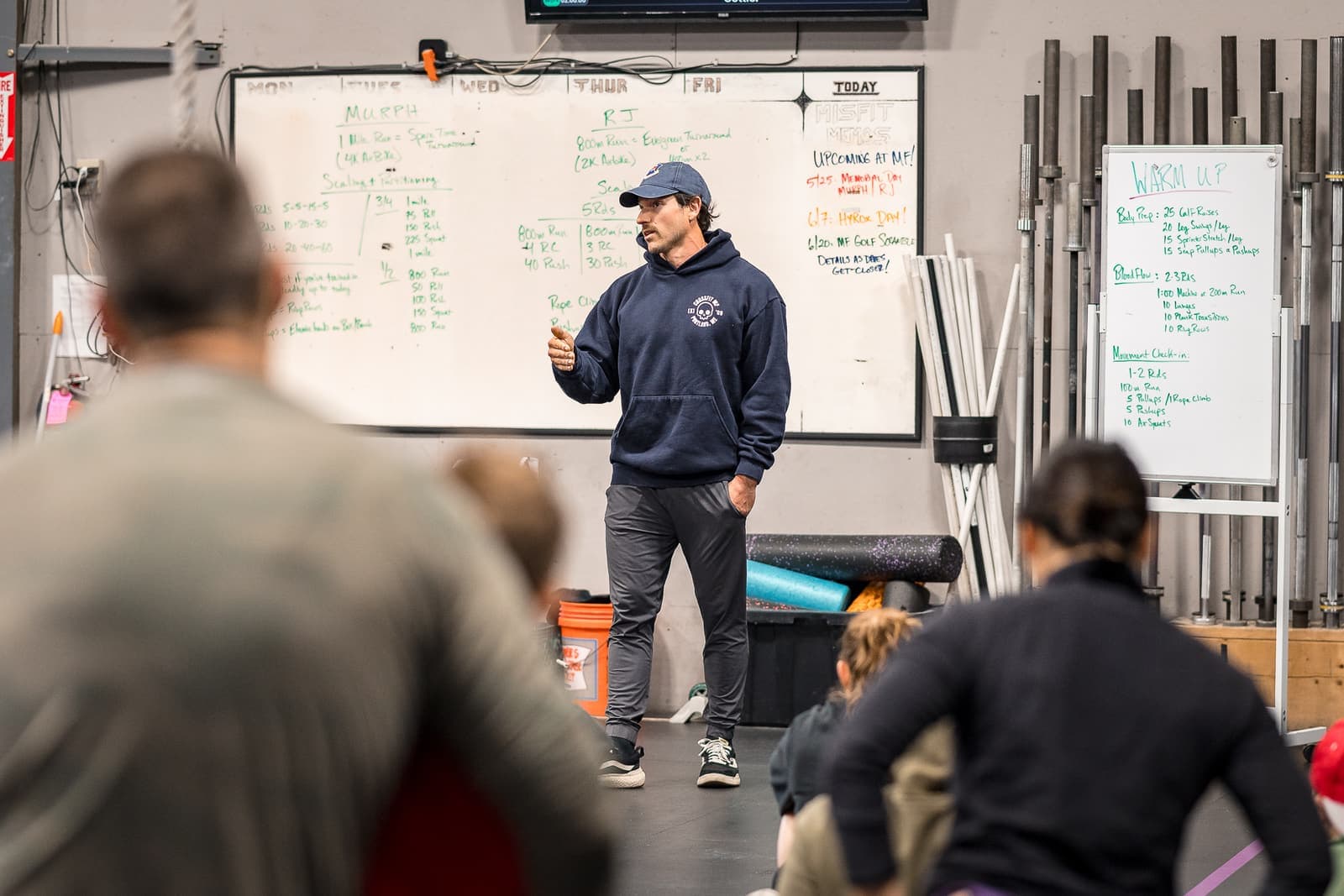 The coach briefing a seated class at the whiteboard before the workout