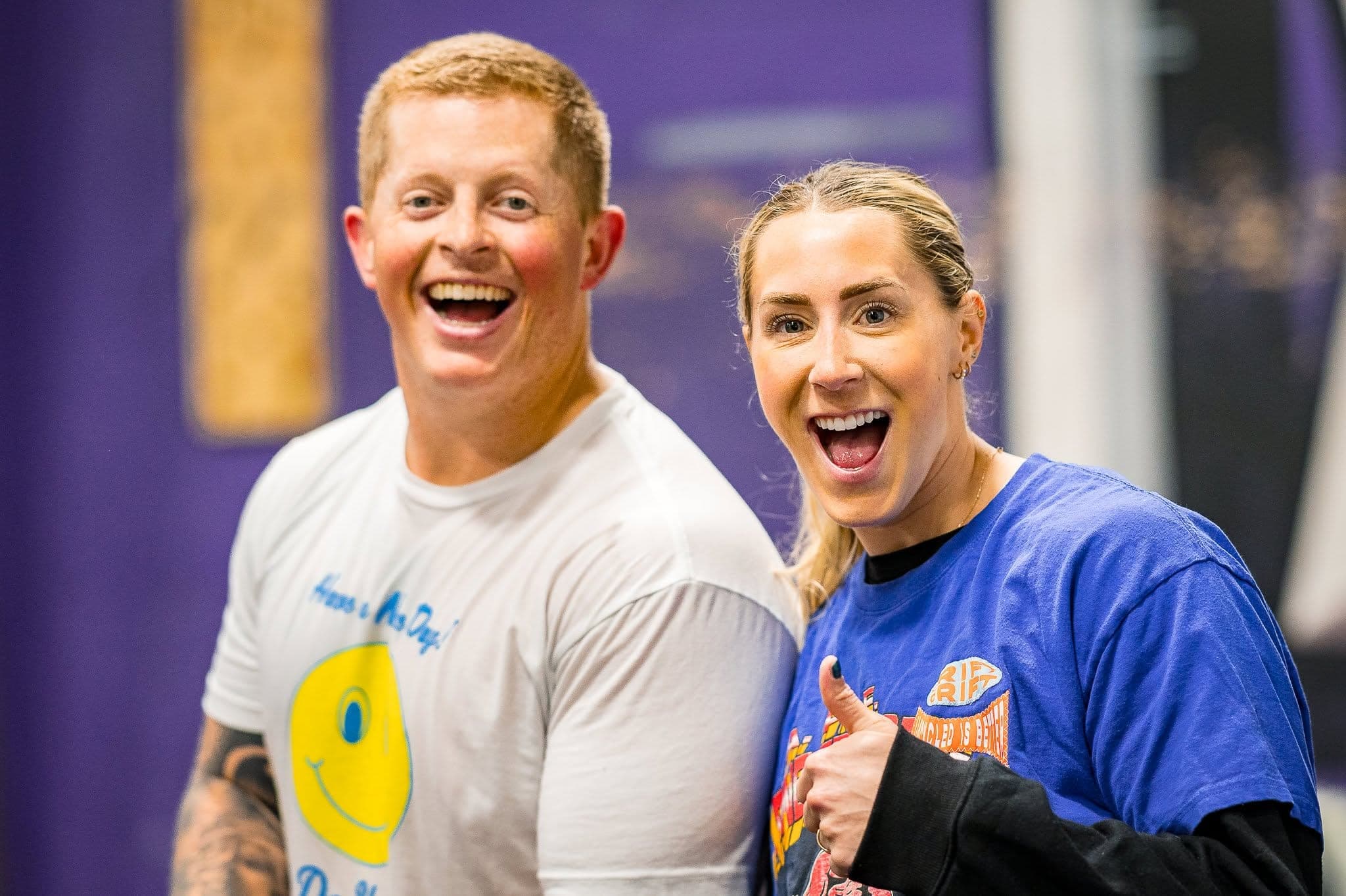 Two Misfit members grinning at the camera between efforts, one of them throwing a thumbs up