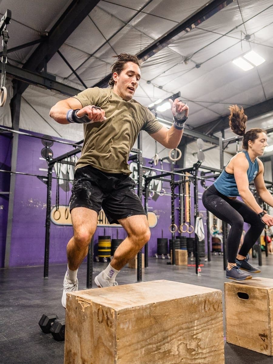 Two Misfit members exploding onto boxes mid-jump in front of the purple wall