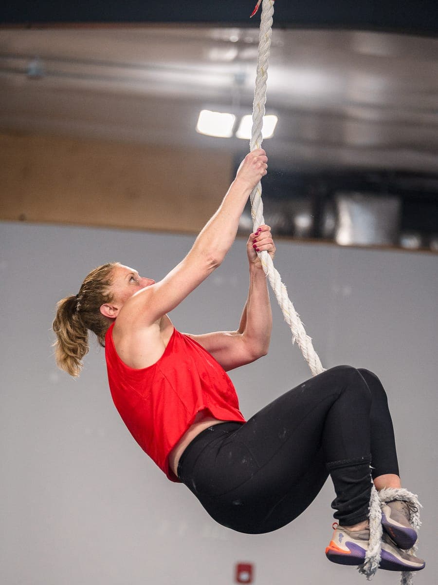 Misfit member climbing the rope, legs wrapped mid-ascent